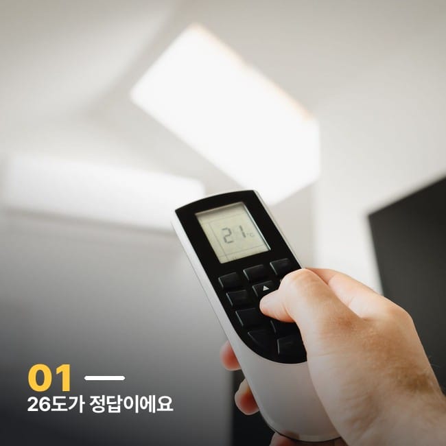 에어컨 리모컨으로 온도를 조절하는 손