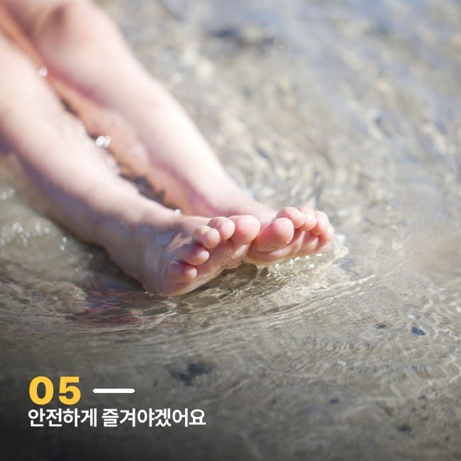 얕은 물에 담근 아이 맨발