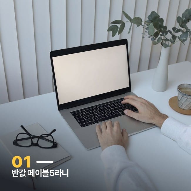 책상에서 노트북으로 작업하는 손