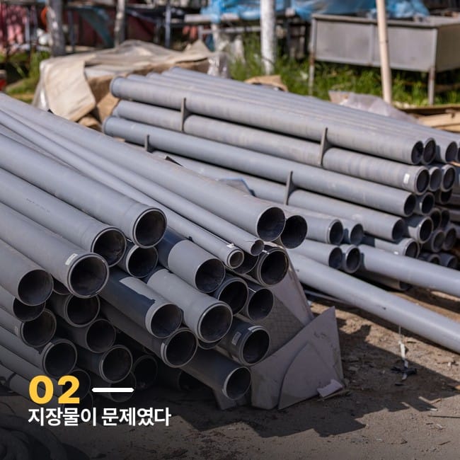 공사 현장에 쌓여 있는 회색 배관 자재 더미