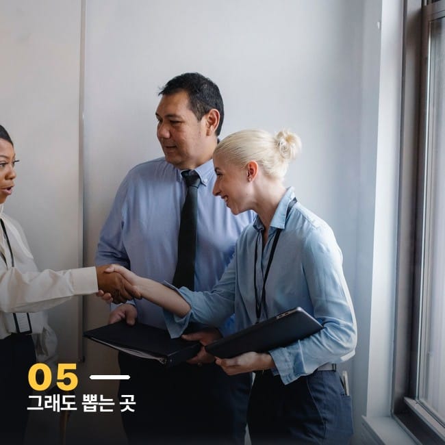 사무실에서 여러 사람이 악수를 나누는 사진