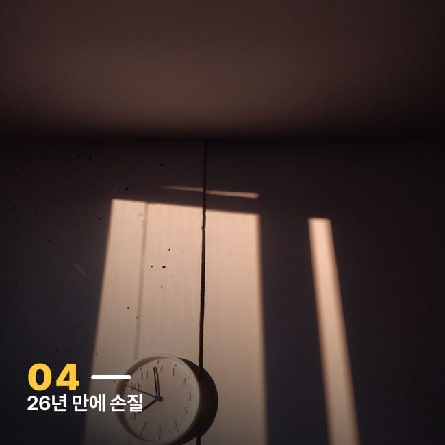 햇빛이 드는 벽에 걸린 미니멀한 시계