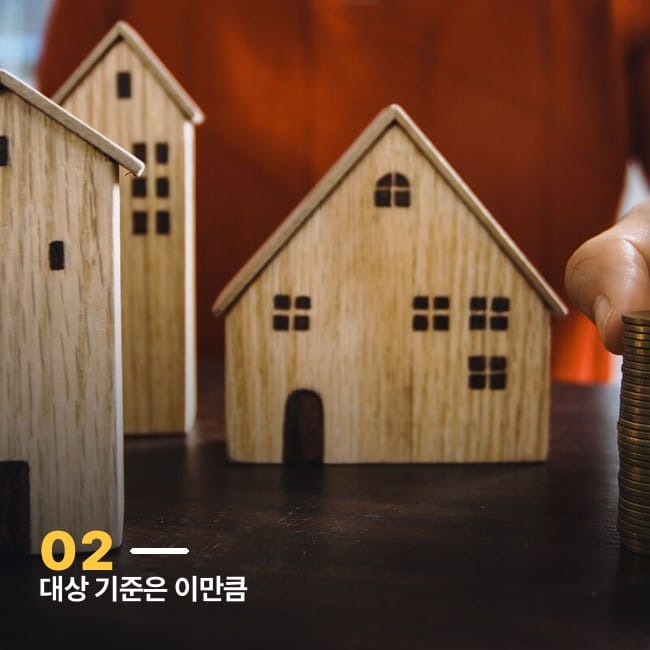 미니어처 목조주택 여러 채와 동전을 쌓는 손