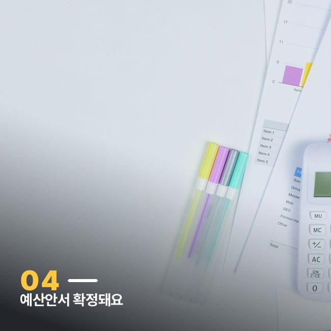 계산기와 예산 그래프가 놓인 책상