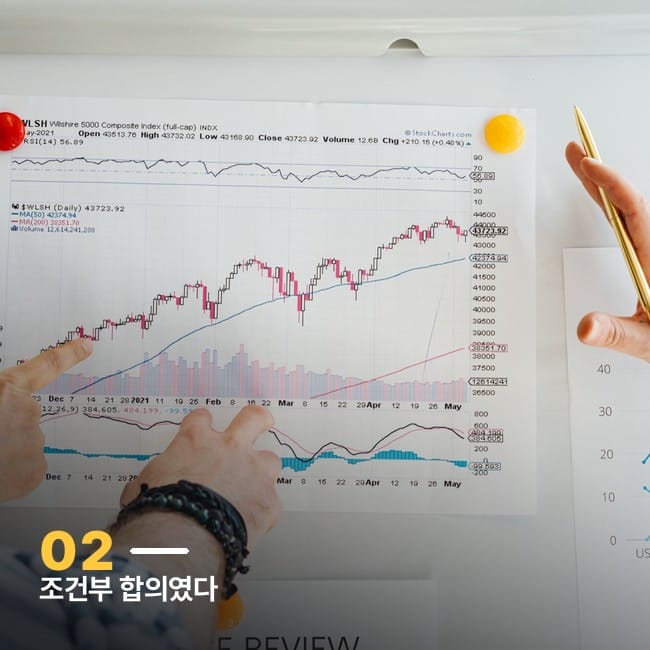 출력한 주가 차트를 손으로 짚으며 분석하는 사진, 조건부 합의를 상징하는 이미지