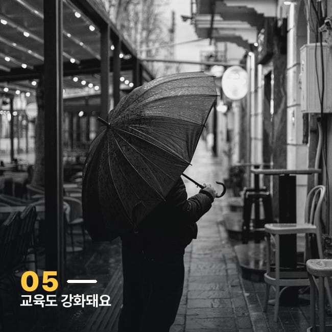 비 오는 골목에서 우산을 쓴 사람의 뒷모습