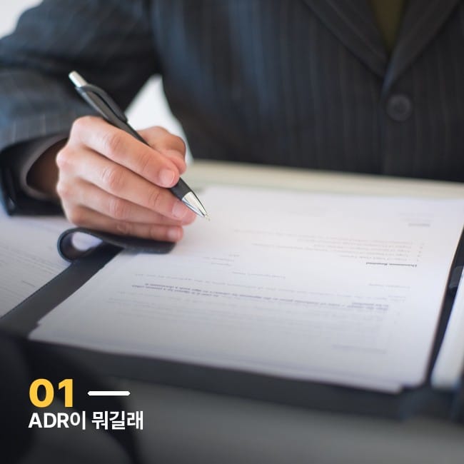 계약서에 서명하는 손 클로즈업 사진, ADR 예탁증서 개념을 상징하는 이미지