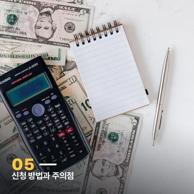 지폐 위에 놓인 계산기와 메모장, 펜