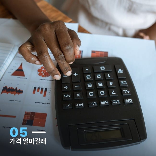 계산기와 재무 차트가 놓인 책상 사진, FSD 라이트 가격 정책 변화를 상징하는 이미지
