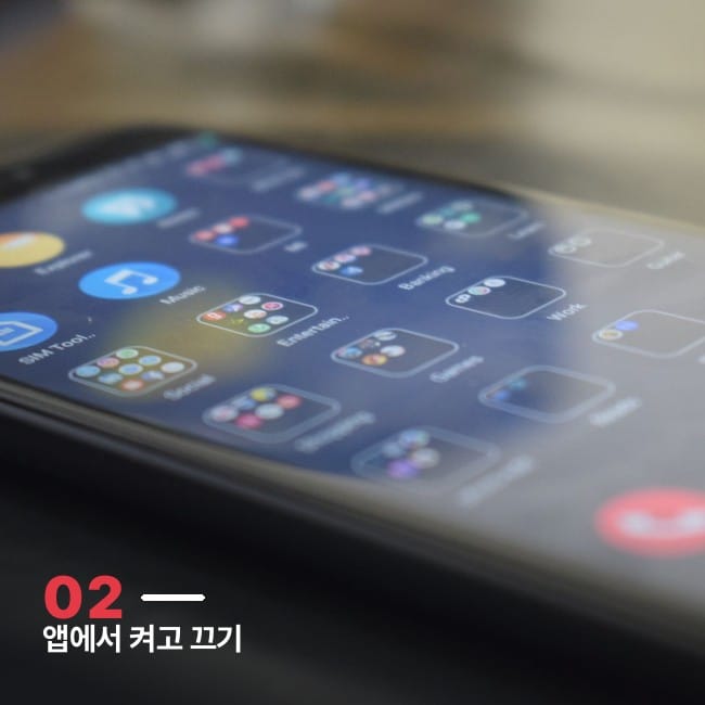 스마트폰 화면에 여러 앱 아이콘이 흐릿하게 보이는 사진, FSD 구독 온오프 관리 개념을 상징하는 이미지