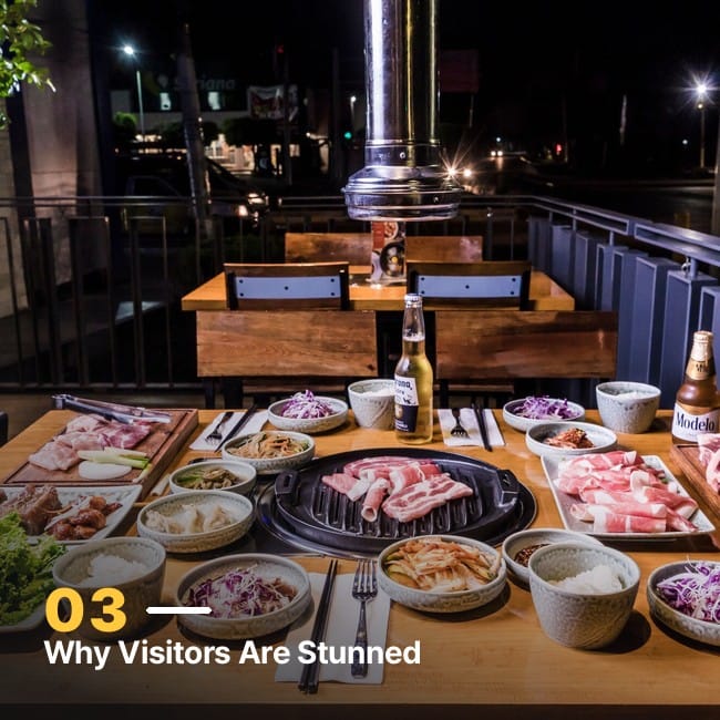 A Korean barbecue table spread with grilled meat and a wide variety of banchan