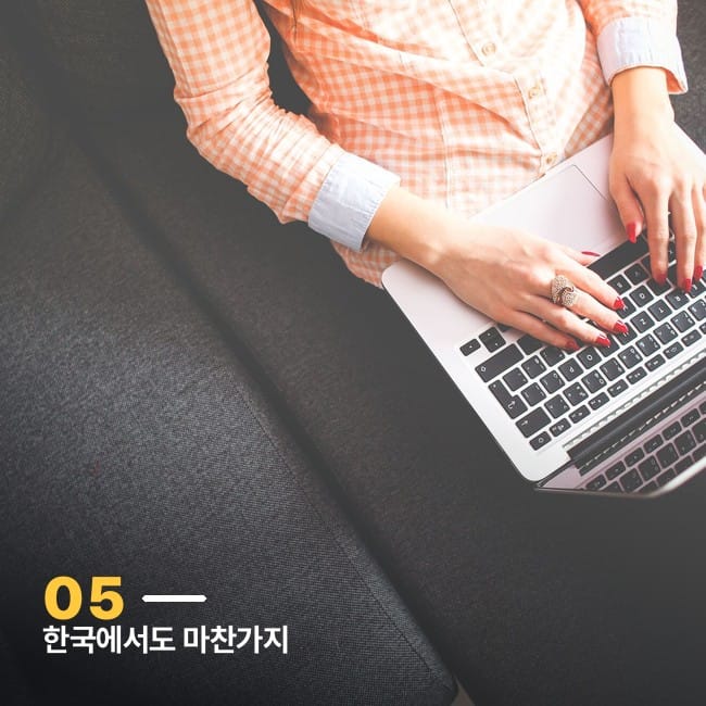 소파에 앉아 노트북 자판을 치는 손 클로즈업