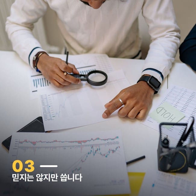 돋보기로 서류 위 그래프를 들여다보는 손